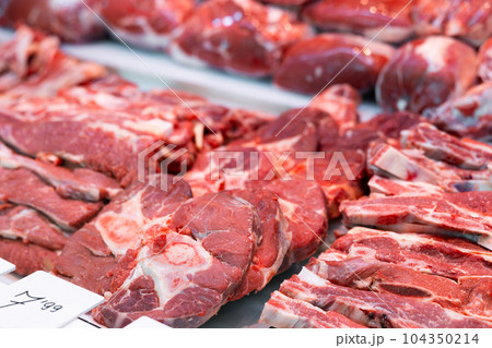 Slice of raw beef tenderloin and veal in packing tray on window refrigerator 104350214