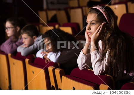 Children watch with interest performance in theater or concert 104350886