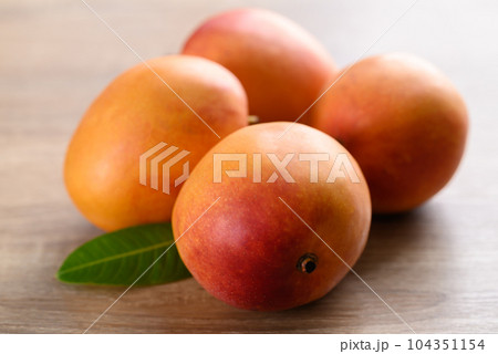 Ripe Mango fruit (Tommy Atkins) on wooden background, Tropical fruit 104351154