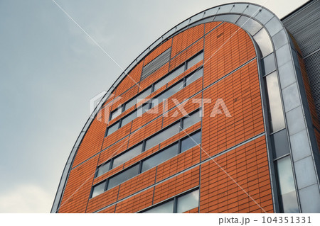 Modern glass office building exterior with glass facade on clear sky background. Transparent glass wall of office building. Element of facade of modern European building Commercial office buildings Modern glass office building exterior with glass facade on clear sky background. Transparent glass wall of office building. Element of facade of modern European building Commercial office buildings 104351331