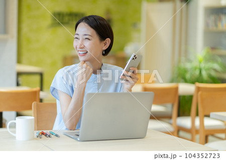 スマホを持った女性 コワーキングスペースで働く女性 働く女性 スマホを持った女性 コワーキングスペースで働く女性 働く女性 104352723