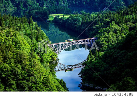 只見線　初夏の第一只見川橋梁を渡る車両キハE120形(福島県三島町、6月下旬早朝) 104354399