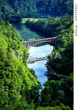 只見線　初夏の第一只見川橋梁を渡る車両キハE120形(福島県三島町、6月下旬早朝) 104354401