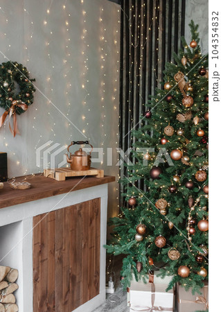 Home New Year's interior. Christmas tree with gifts, decorated with garlands in the kitchen. Cozy atmosphere of a home holiday, loft design of the room, Scandinavian style. Home New Year's interior. Christmas tree with gifts, decorated with garlands in the kitchen. Cozy atmosphere of a home holiday, loft design of the room, Scandinavian style. 104354832