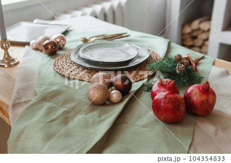 Serving a festive Christmas table in Scandinavian style. Decor on the table before the holiday. Serving a festive Christmas table in Scandinavian style. Decor on the table before the holiday. 104354833