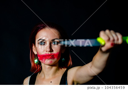 Gorgeous redhead woman with bloody knife in her hand close-up 104356459