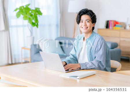 リビングでテレワークをする若い男性 104356531