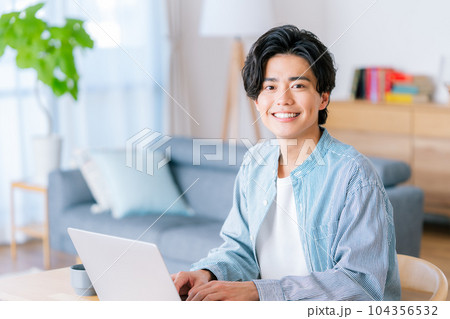 リビングでテレワークをする若い男性 104356532