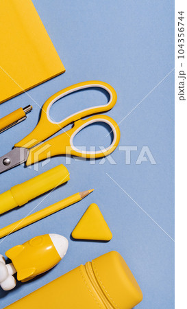 Assorted office and school yellow stationery on lilac blue. copy space for back to school or education craft office work concept. Bright Yellow rocket. Achievement and success. Top view 104356744