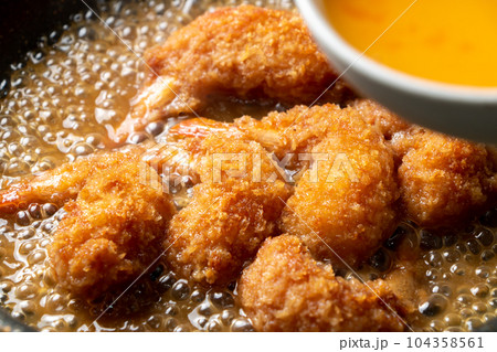 残り物揚げ物(エビフライ)リメイク(卵とじ)調理シーン。だし汁で煮たエビフライに溶き卵を加える。 残り物揚げ物(エビフライ)リメイク(卵とじ)調理シーン。だし汁で煮たエビフライに溶き卵を加える。 104358561