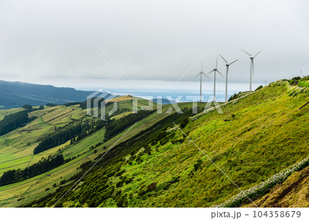 Panoramic view of wind farm or wind park, with high wind turbines for generation electricity 104358679