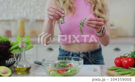 Close up young girl in the process of preparing healthy food. Healthy eating and cooking concept. Close up young girl in the process of preparing healthy food. Healthy eating and cooking concept. 104359008