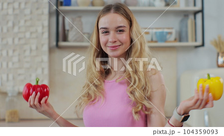 Smiling woman covering eyes with red and yellow peppers. Happy girl with fresh vegetables. Healthy eating. Vegetable diet concept. Smiling woman covering eyes with red and yellow peppers. Happy girl with fresh vegetables. Healthy eating. Vegetable diet concept. 104359093