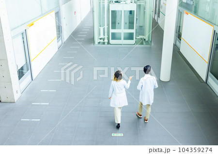 白衣を着て施設を歩く多国籍グループ 白衣を着て施設を歩く多国籍グループ 104359274