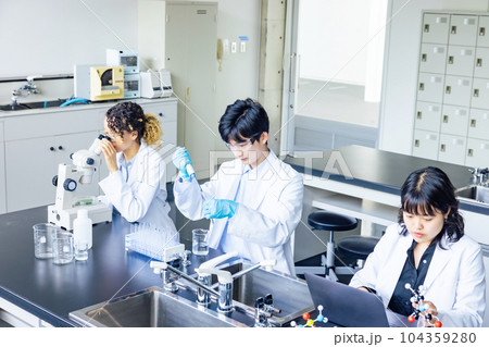 研究室で実験する多国籍研究者グループ 104359280