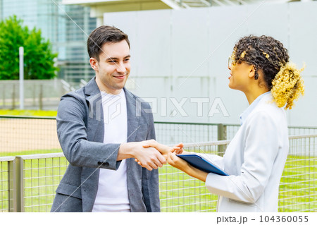 屋外で握手する外国人グループ 104360055