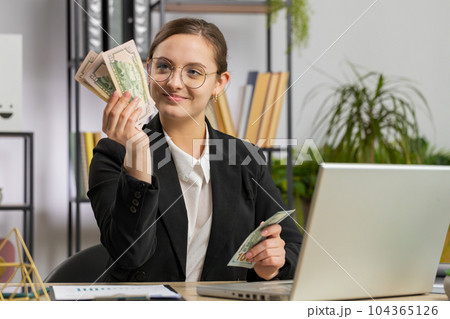 Rich happy business woman working on laptop pc counting money cash, calculate earnings income profit 104365126