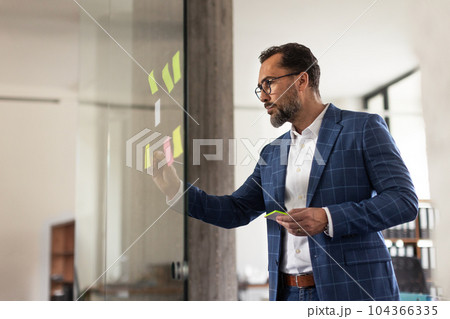 Young man taking notes in his office. 104366335