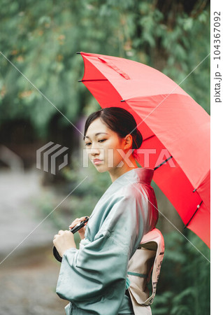 自然溢れる中で赤い傘をさす和服の若い女性 自然溢れる中で赤い傘をさす和服の若い女性 104367092