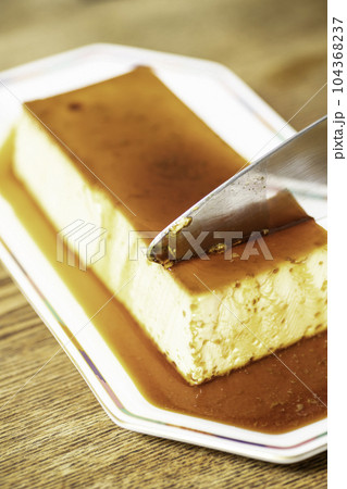 大きなプリンをケーキサーバーで取り分ける 大きなプリンをケーキサーバーで取り分ける 104368237