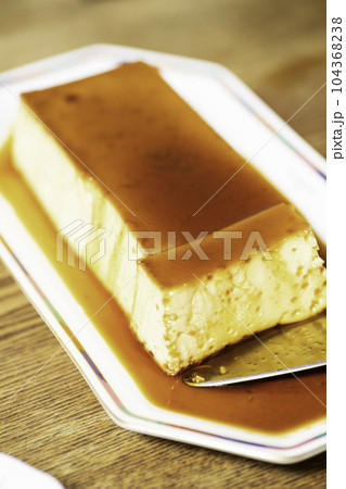 大きなプリンをケーキサーバーで取り分ける 大きなプリンをケーキサーバーで取り分ける 104368238