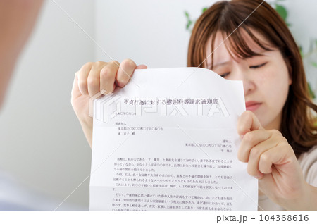 不倫についての書類を見せる女性 104368616