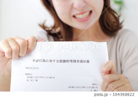 不倫についての書類を見せる女性 104368622