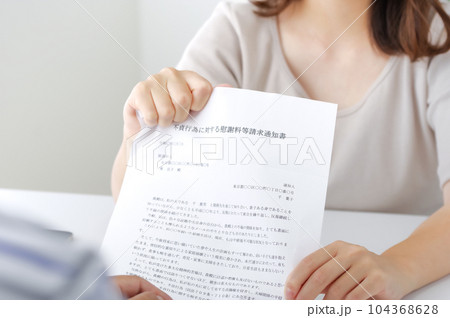 不倫についての書類を見せる女性 104368628