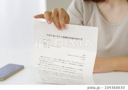 不倫についての書類を見せる女性 104368630