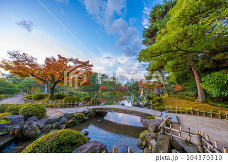 秋晴れの青空と紅葉が美しい兼六園霞ヶ池のことじ灯篭の風景 104370310