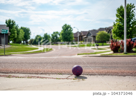 Chasing a ball that has crossed the street by rolling into a road. Chasing a ball that has crossed the street by rolling into a road. 104371046