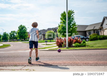 Chasing a ball that has crossed the street by rolling into a road. Chasing a ball that has crossed the street by rolling into a road. 104371047