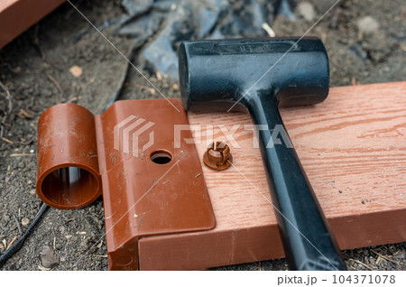 Assembling a raised bed garden panel with plastic connectors using a rubber mallet.  104371078
