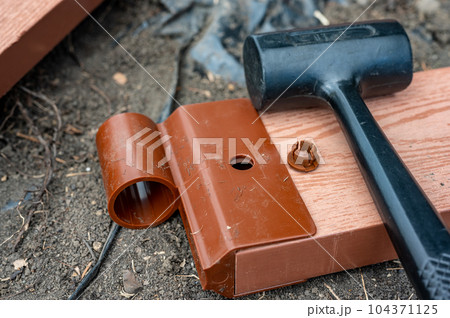 Assembling a raised bed garden panel with plastic connectors using a rubber mallet.  104371125