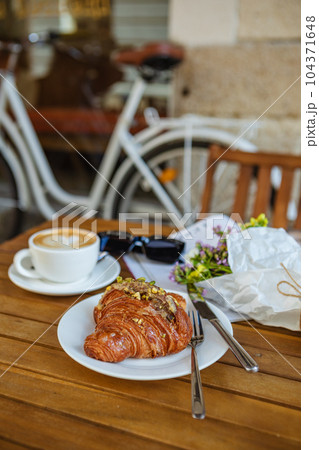 Breakfast time: Dessert with Croissant, Coffee, and Magazine in Cafe Breakfast time: Dessert with Croissant, Coffee, and Magazine in Cafe 104371648