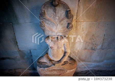 Image of a headless Buddha sculpture in the lotus position located in a Cambodian temple. 104373230