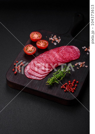 Delicious smoked salami sausage with salt, spices and herbs cut into slices 104373613