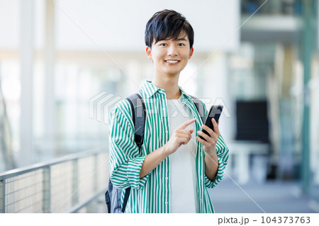 スマホを持って歩く大学生 スマホを持って歩く大学生 104373763
