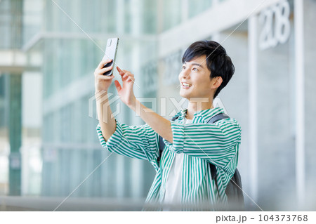 スマホを持って歩く大学生 スマホを持って歩く大学生 104373768
