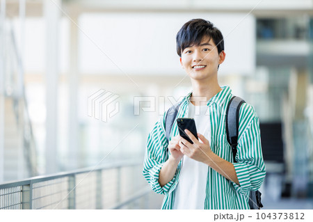 スマホを持って歩く大学生 104373812
