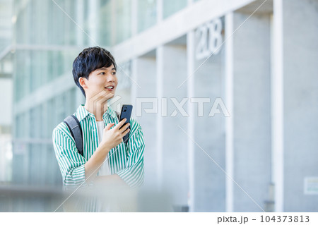スマホを持って歩く大学生 104373813