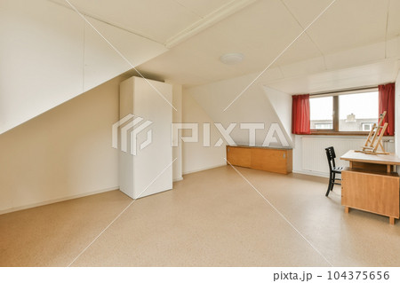 an empty room with red curtains on the window and desk in the room is very clean, but it's no longer than 104375656