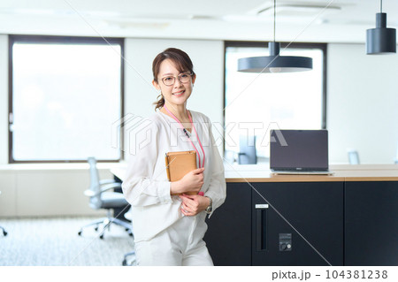 手帳を持ちオフィスに立つ女性 104381238