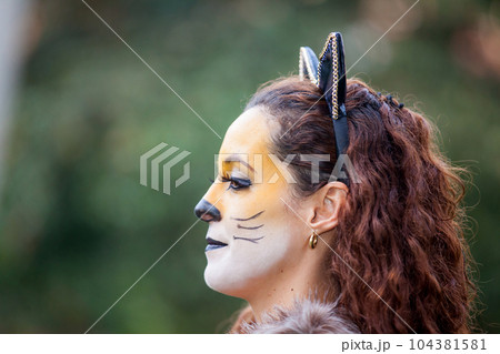 Beautiful young woman wearing a wolf costume. Real family having fun while using costumes of the Little red riding hood tale in Halloween. Beautiful young woman wearing a wolf costume. Real family having fun while using costumes of the Little red riding hood tale in Halloween. 104381581