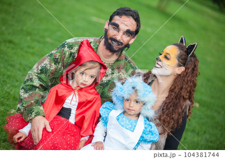 Real family having fun while using costumes of the Little red riding hood tale in Halloween. Real family having fun while using costumes of the Little red riding hood tale in Halloween. 104381744