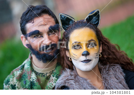 Young couple wearing wolf and woodcutter costumes. Real family having fun while using costumes of the Little red riding hood tale in Halloween. Young couple wearing wolf and woodcutter costumes. Real family having fun while using costumes of the Little red riding hood tale in Halloween. 104381801