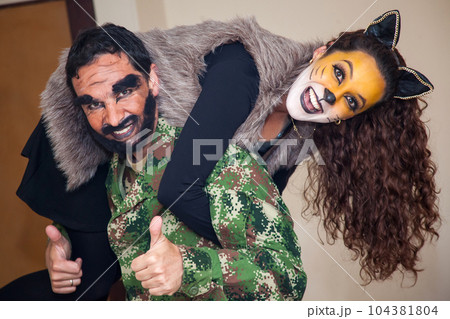 Young couple wearing wolf and woodcutter costumes. Real family having fun while using costumes of the Little red riding hood tale in Halloween. Young couple wearing wolf and woodcutter costumes. Real family having fun while using costumes of the Little red riding hood tale in Halloween. 104381804