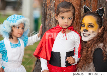 Real family having fun while using costumes of the Little red riding hood tale in Halloween. Real family having fun while using costumes of the Little red riding hood tale in Halloween. 104381879