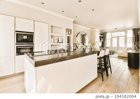a modern kitchen with white cabinets and black counter tops on the island in this room is very spacious, but it's not 104382004