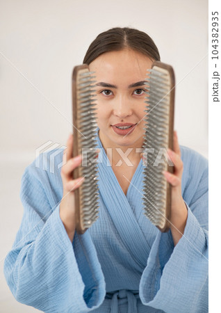 Asian woman holding sadhu boards on face background. Asian woman holding sadhu boards on face background. 104382935
